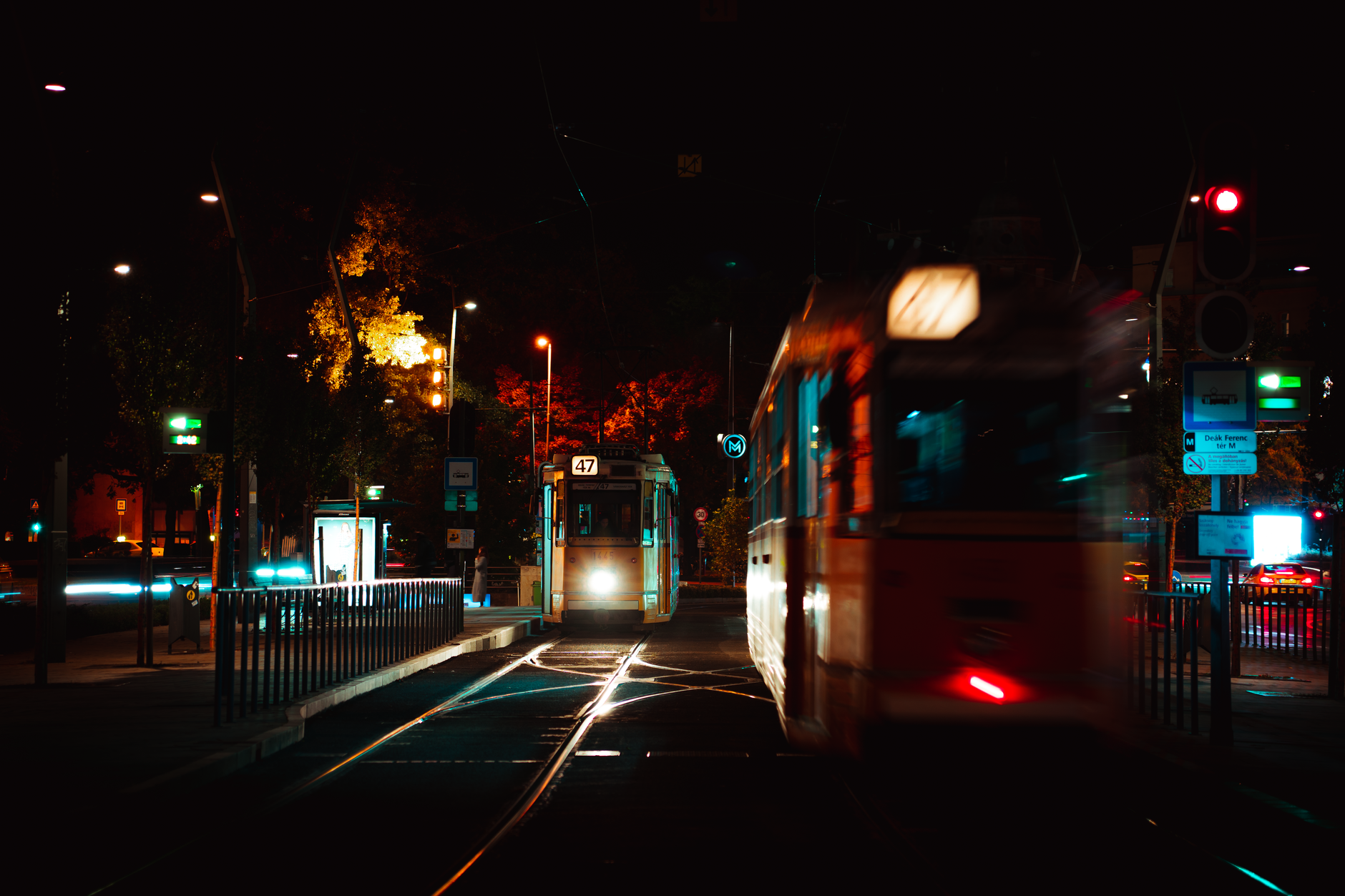 Dynamic night scene of trams on illuminated streets in Budapest.
