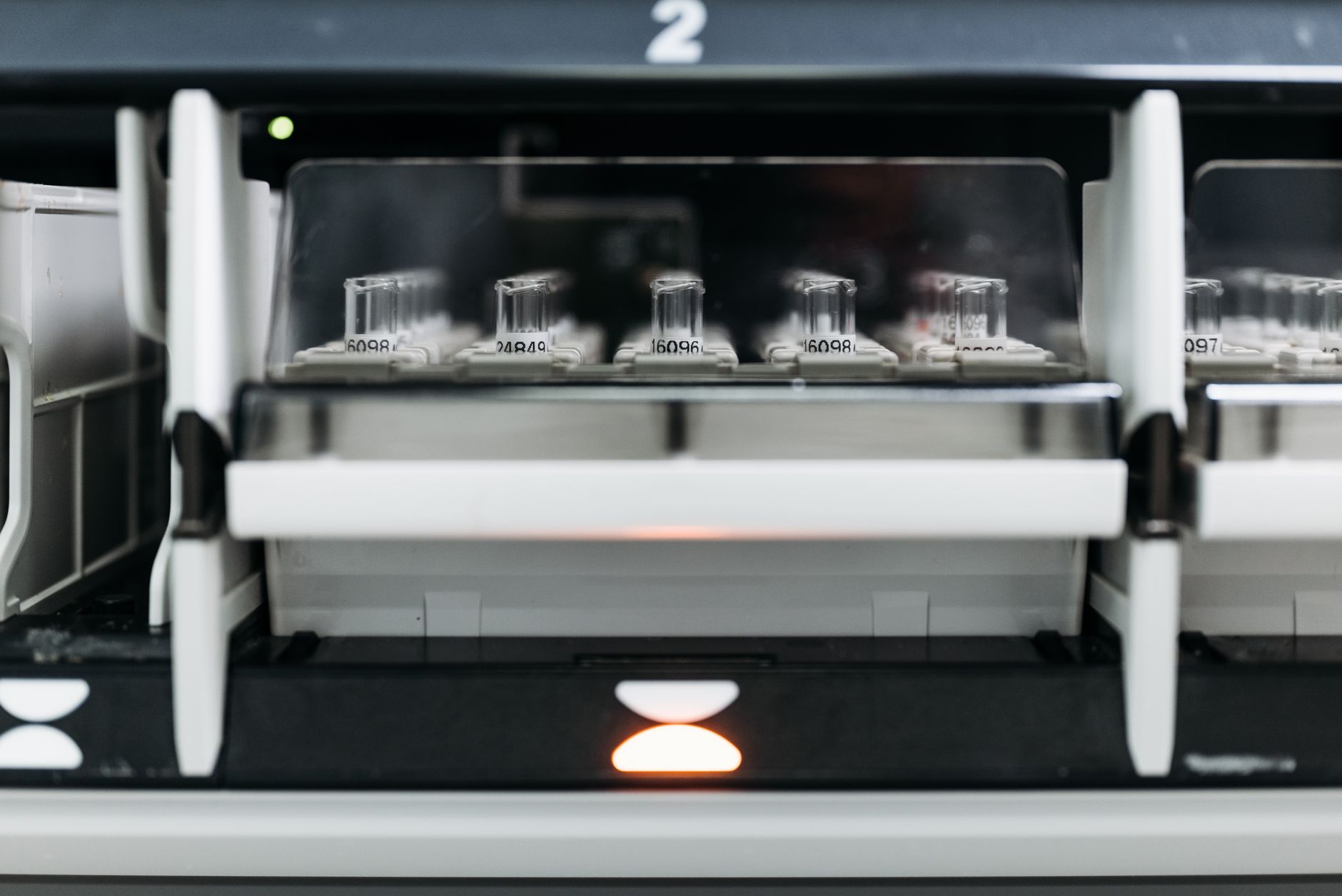 Close-up of laboratory equipment with test tubes in a rack, showcasing modern scientific research tools.