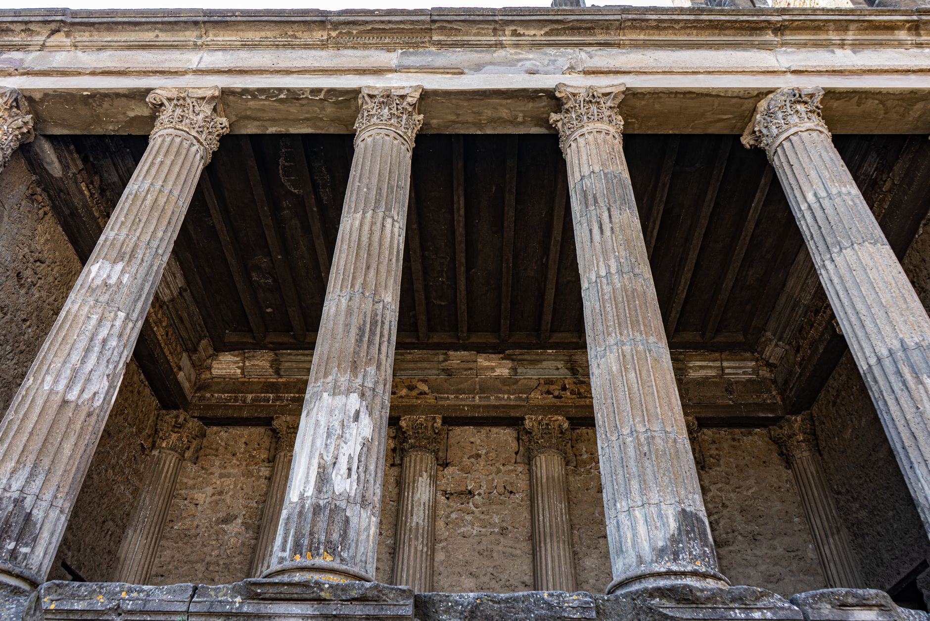 Close-up of ancient Roman columns in Pompeii, showcasing architectural grandeur.
