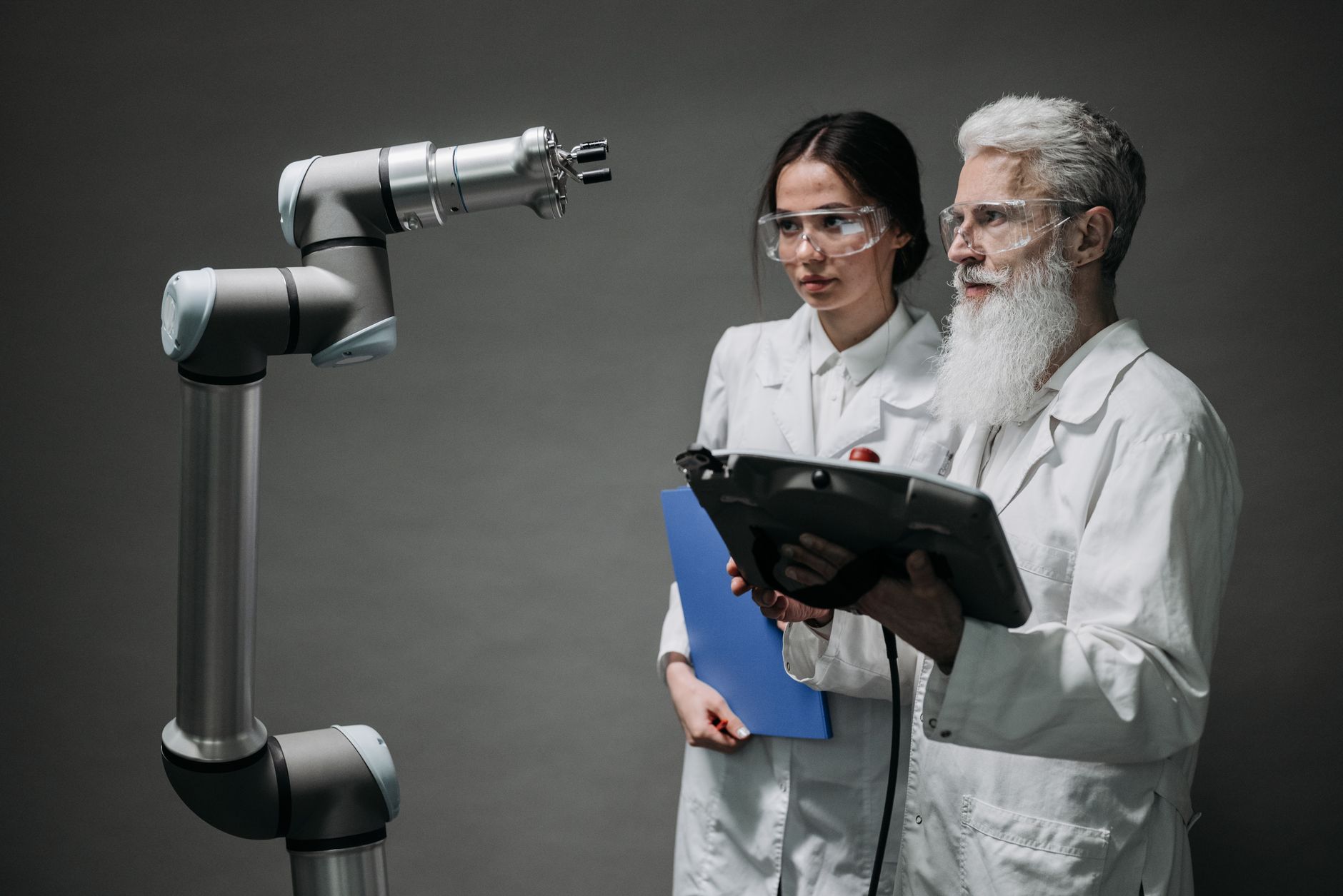 Researchers examining a robotic arm, showcasing technology and innovation.