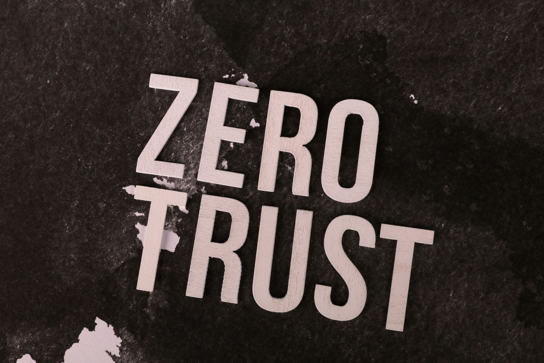 Bold 'Zero Trust' text against a textured black background, symbolizing cybersecurity.
