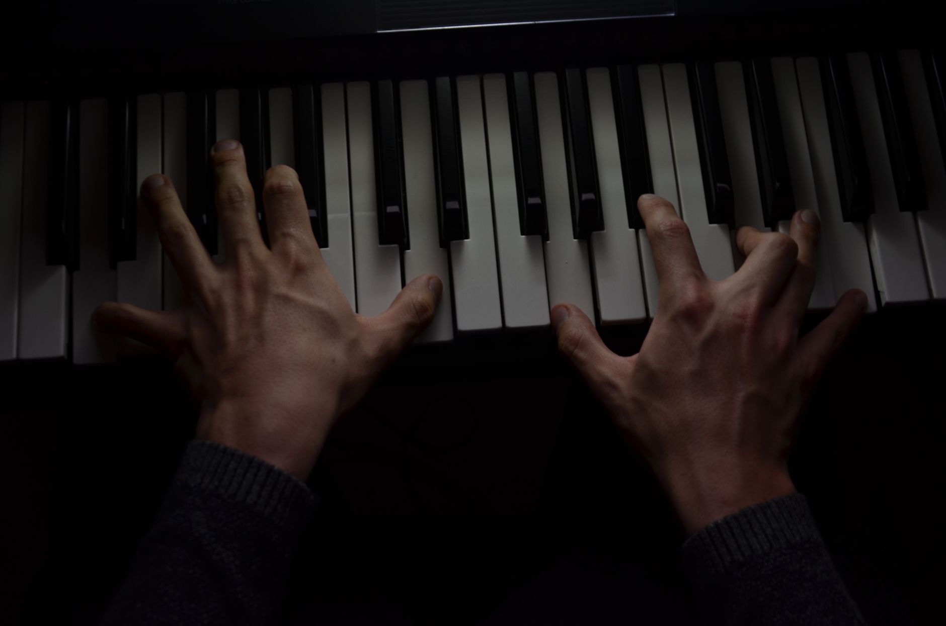 Dramatic close-up of a musician playing piano keys, capturing motion and passion.