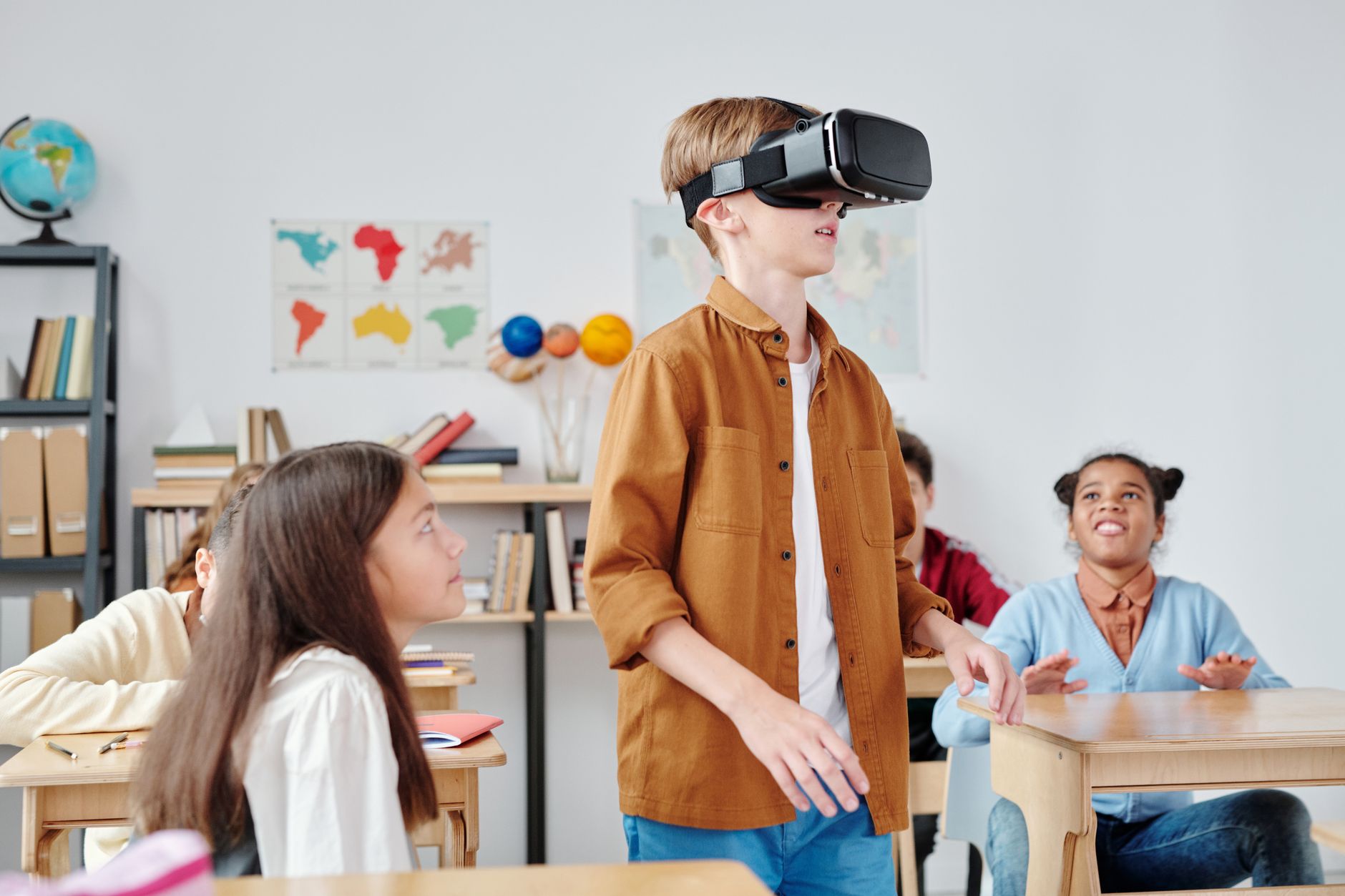 Children engaged with virtual reality headsets in a vibrant classroom setting, exploring immersive technology.
