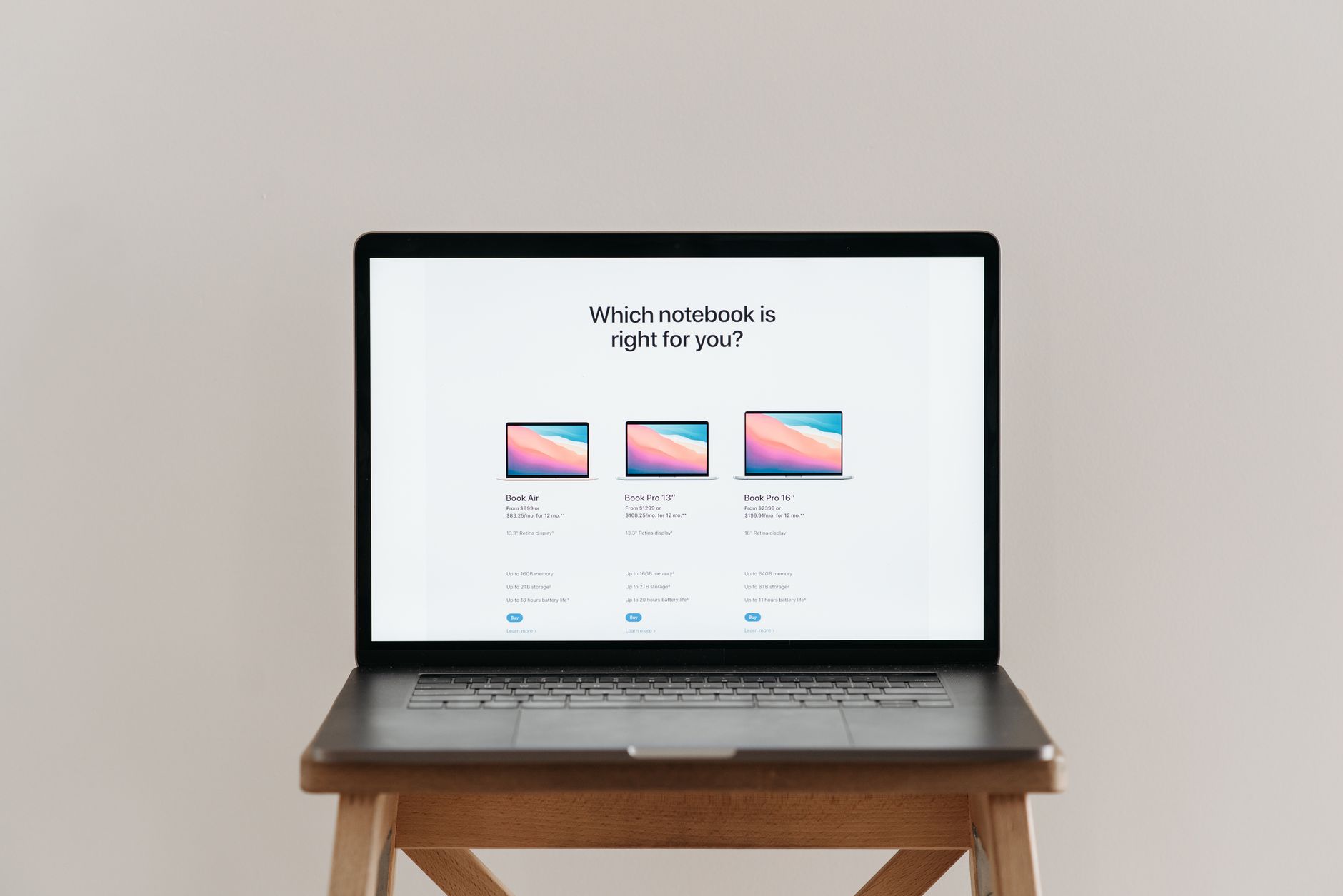 An open laptop on a wooden stool showing a notebook comparison chart, ideal for tech-focused imagery.