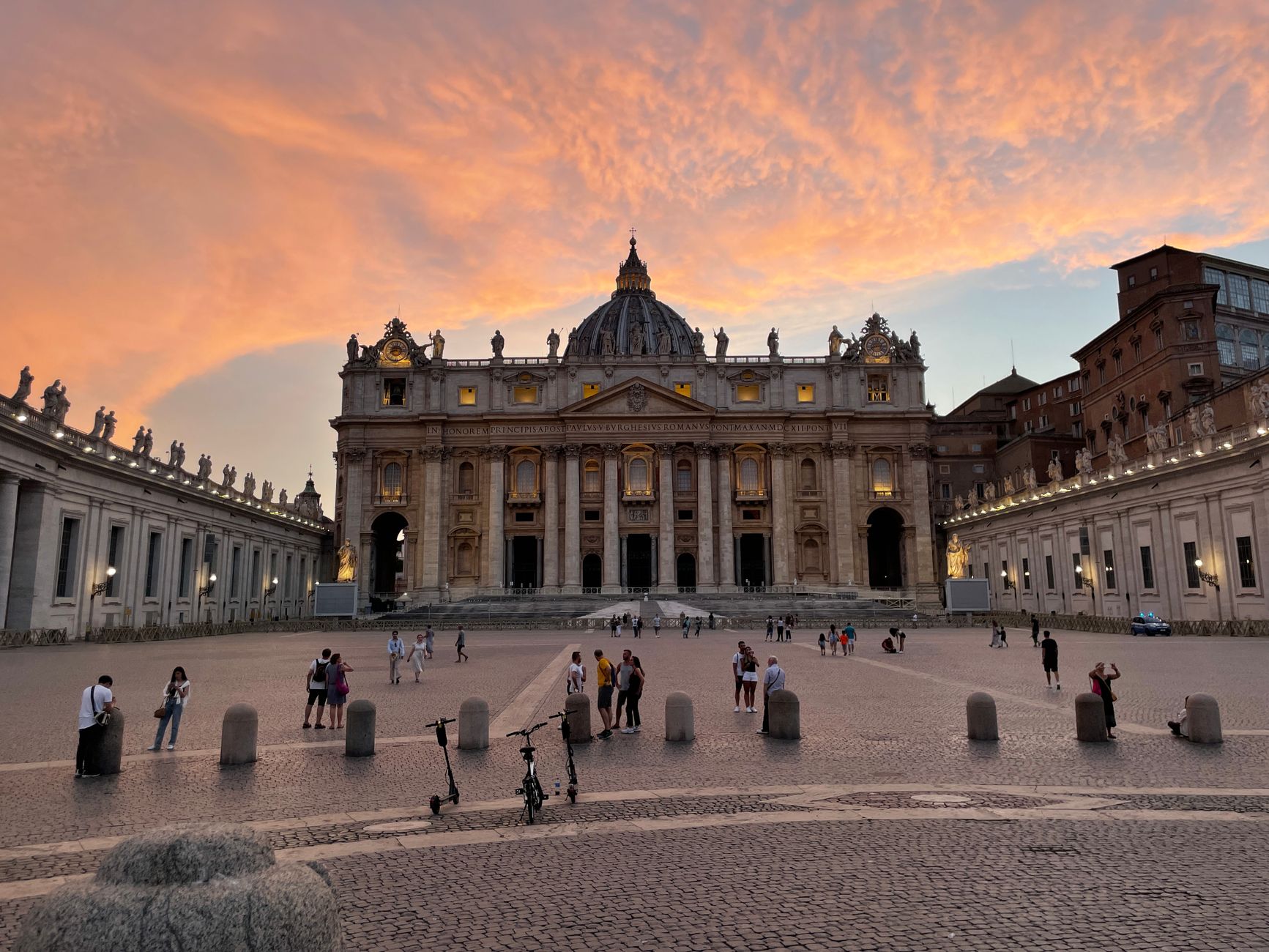 Stunning view of St. Peter's Basilica and Vatican City at sunset with vibrant skies.